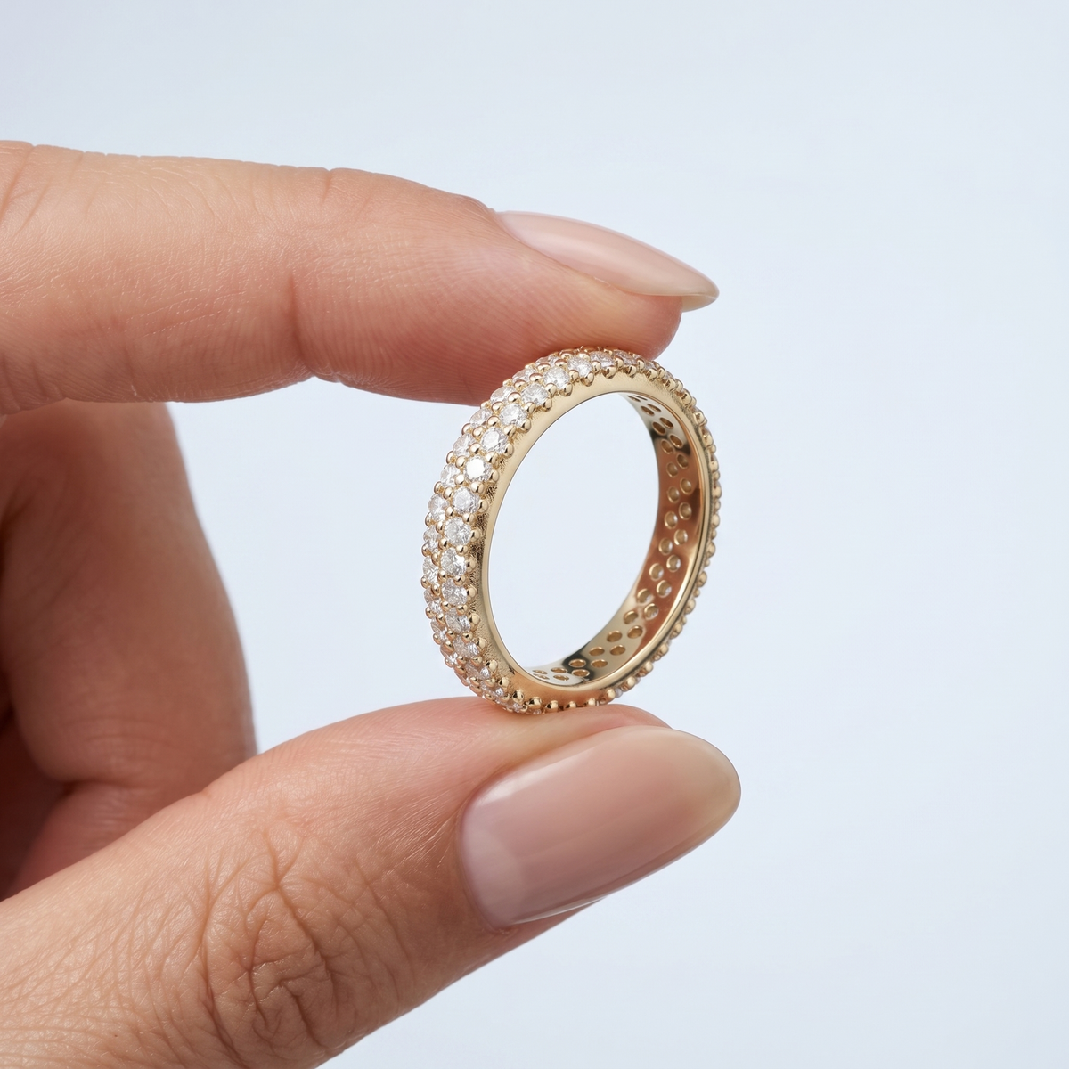 Anello midi pavé di cristalli placcato oro 18K tenuto tra le dita, per vedere le dimensioni reali
