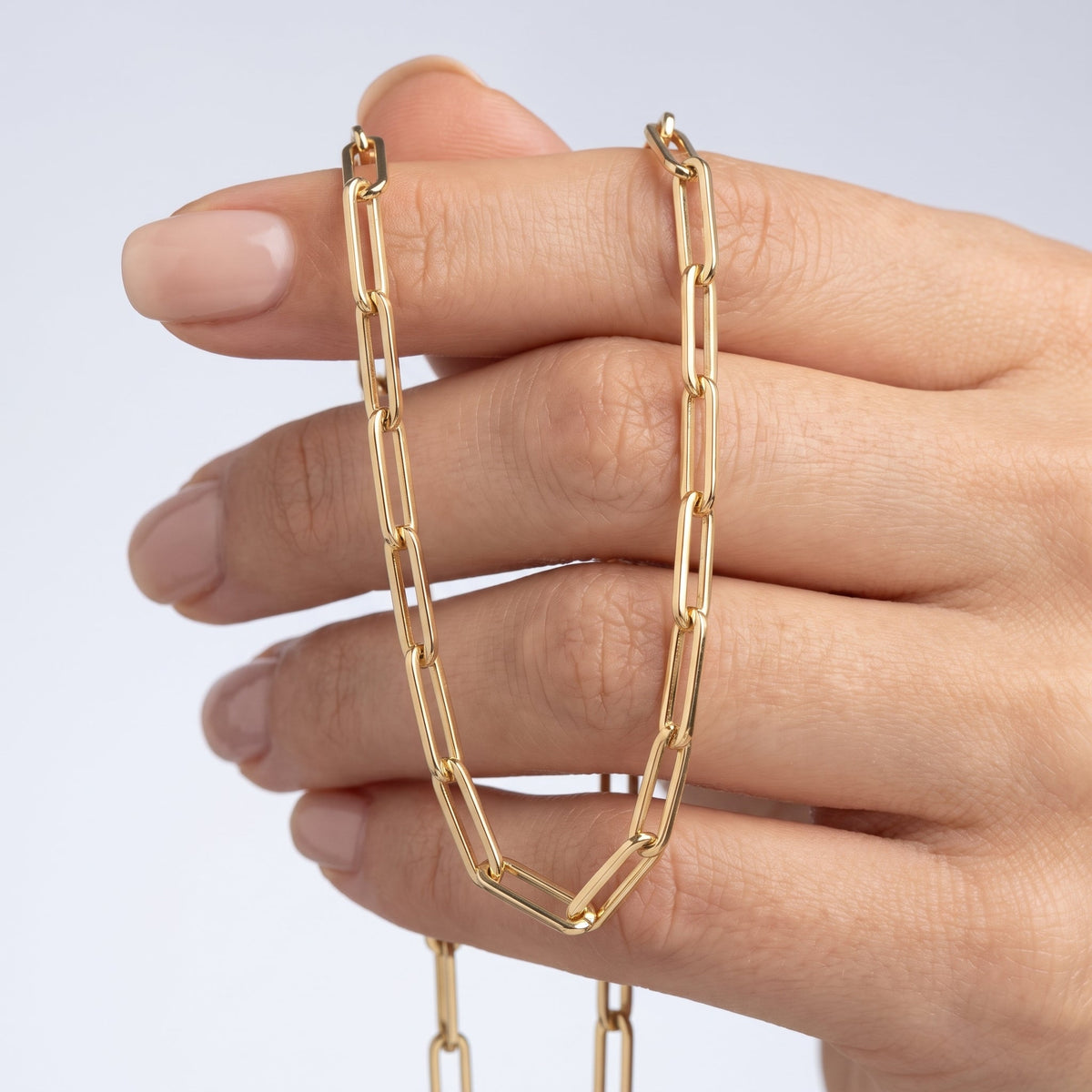 Collana catena paperclip placcata oro 18K tenuta tra le dita, per vedere le dimensioni reali