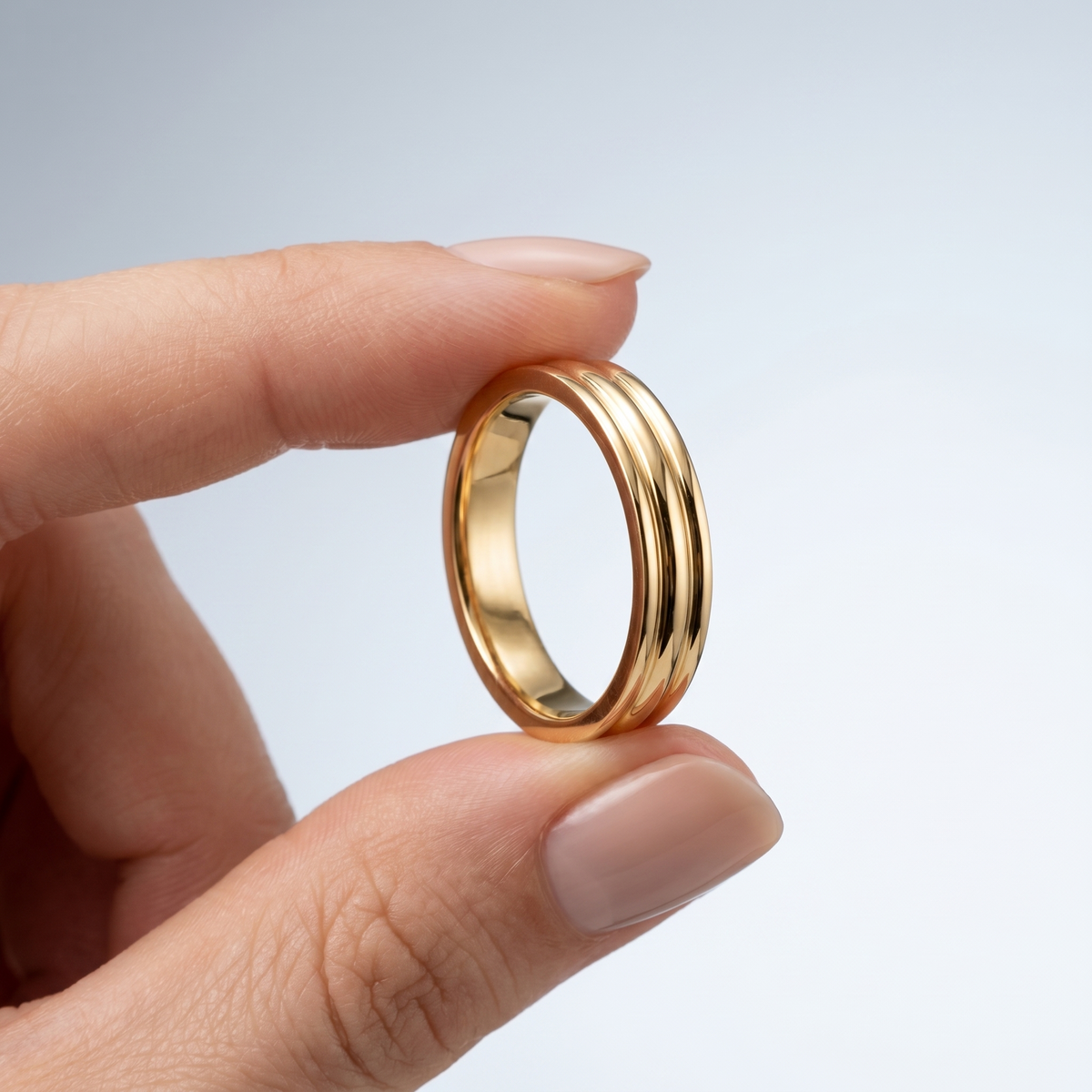 Anello triplo da cerimonia placcato oro 18K tenuto tra le dita, per vedere le dimensioni reali
