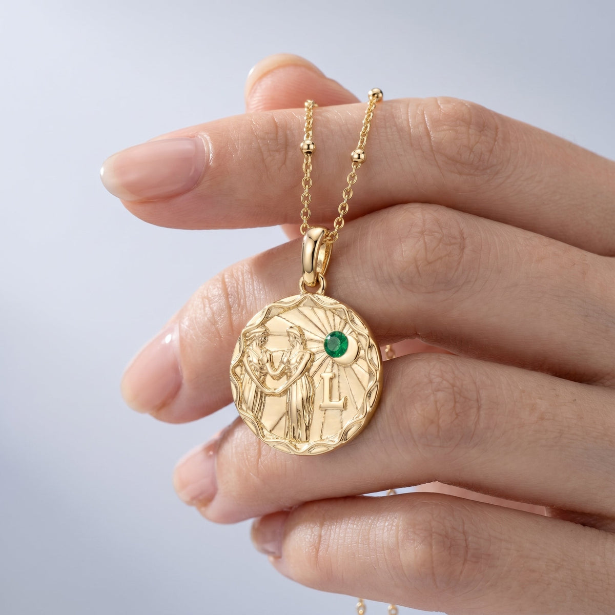 Collar zodiaco personalizado bañado en oro de 18K sostenido entre los dedos, para ver el tamaño real