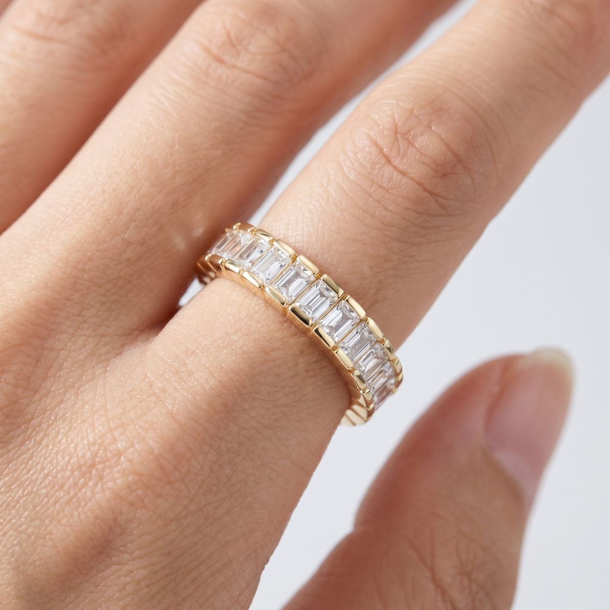 Anillo eternity con circonitas baguette bañado en oro de 18K puesto, primer plano