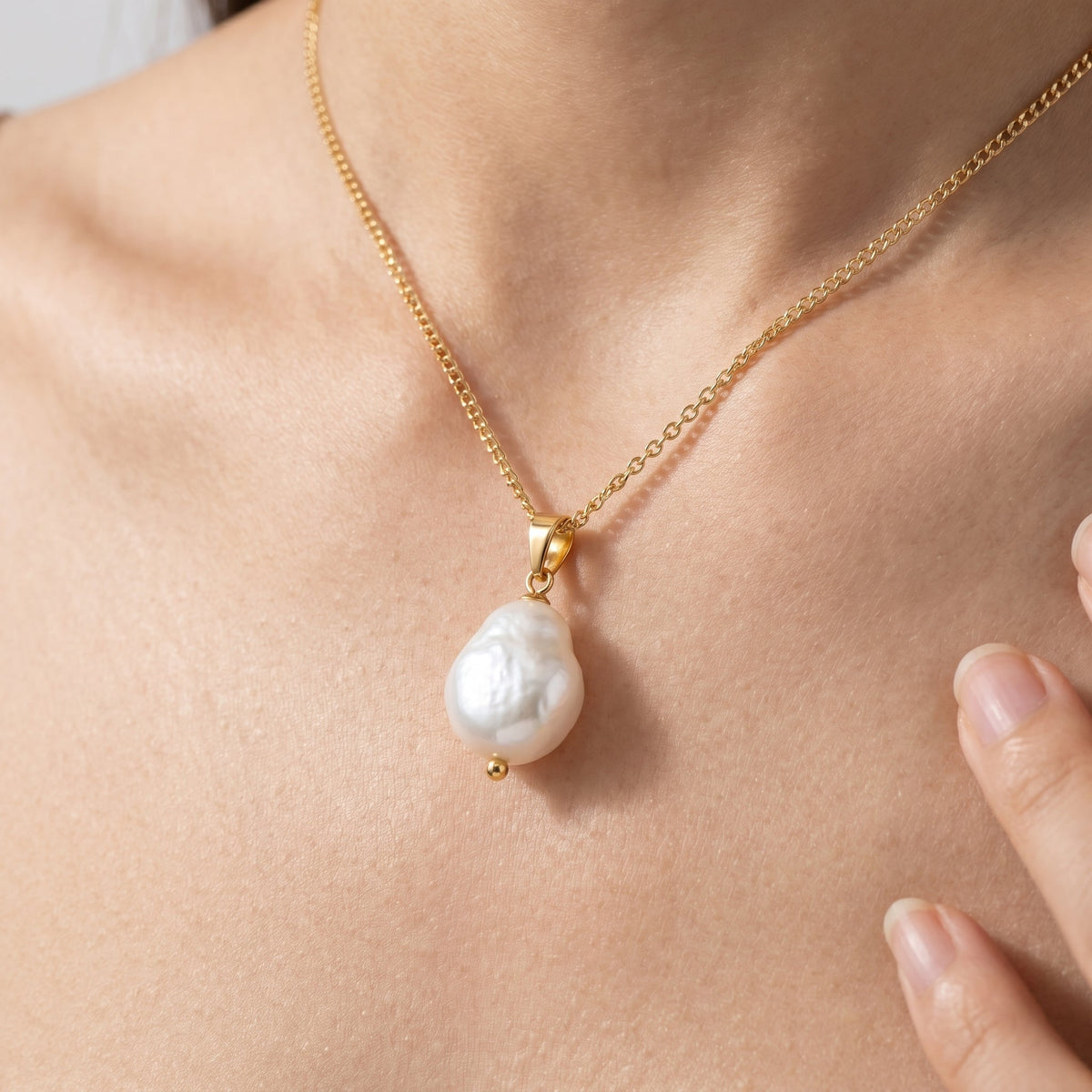Collar con perla barroca grande bañado en oro de 18K puesto, primer plano