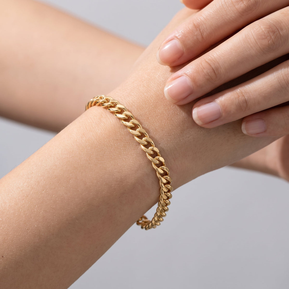 Pulsera de cadena cubana fina bañada en oro de 18K puesta, primer plano