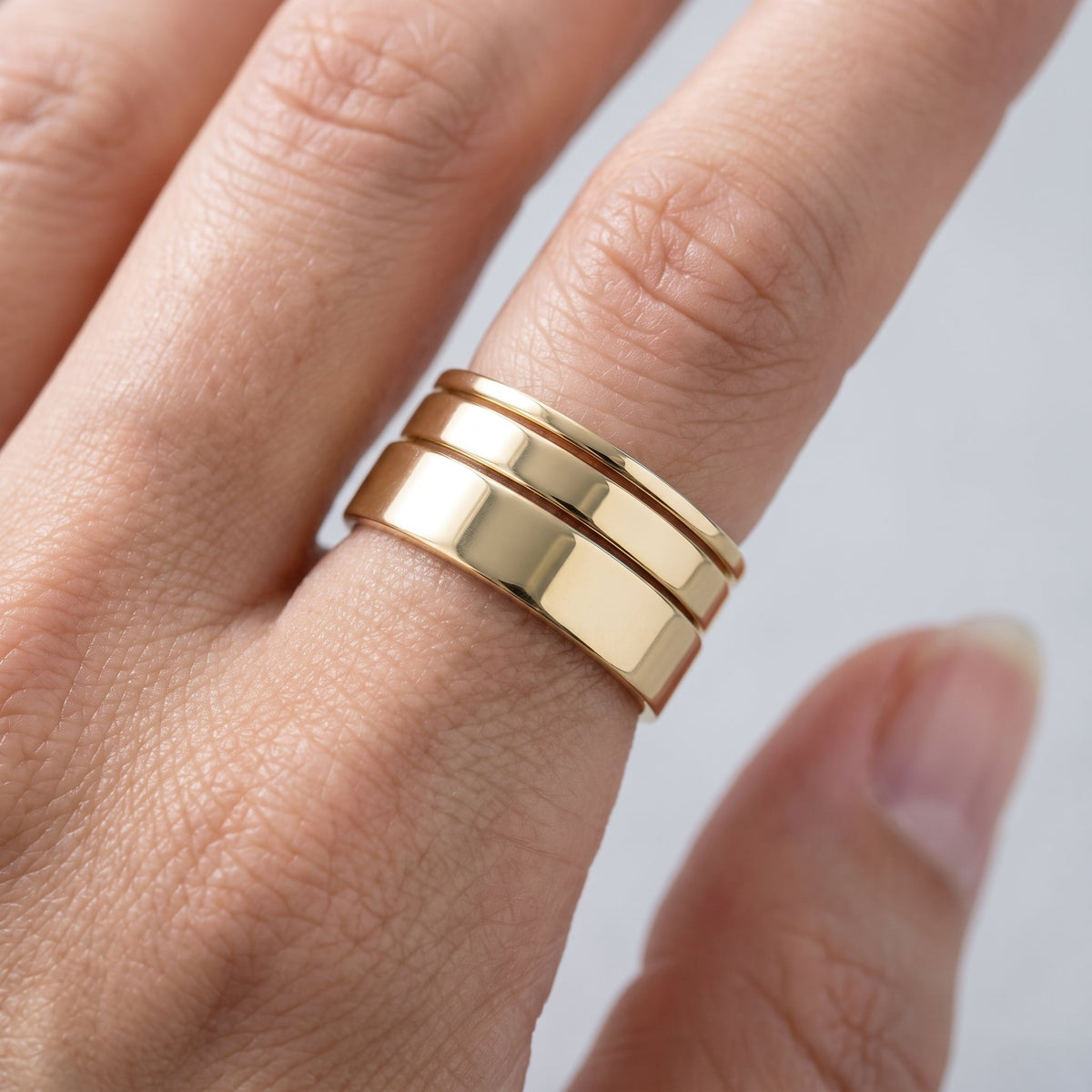 Set de 3 anillos lisos para apilar bañados en oro de 18K puestos, primer plano