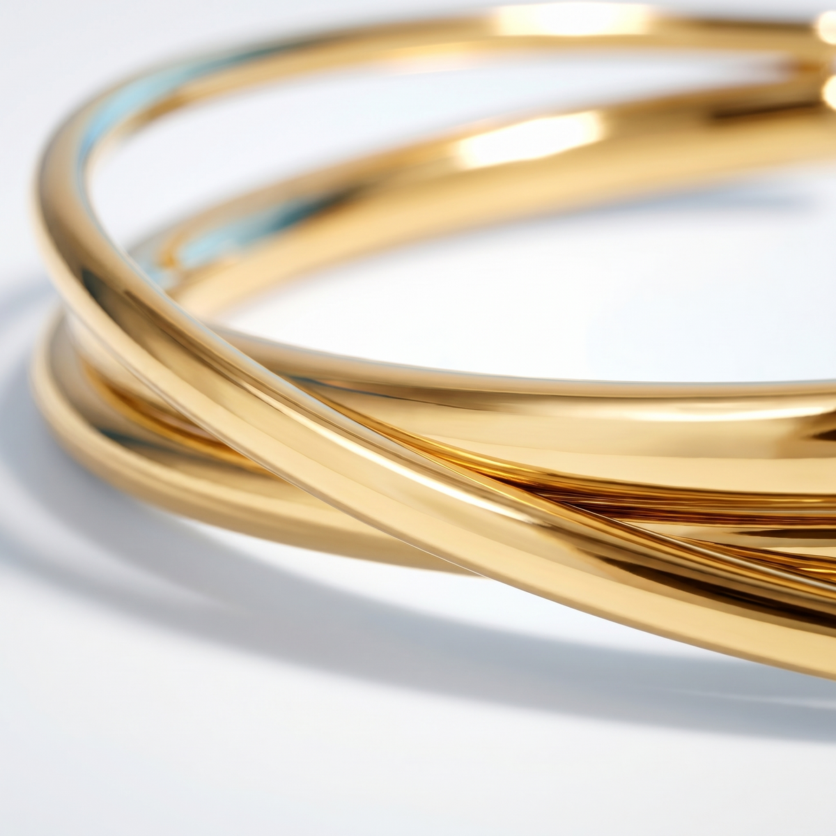 Brazalete rígido cruzado bañado en oro de 18K, detalle de cerca