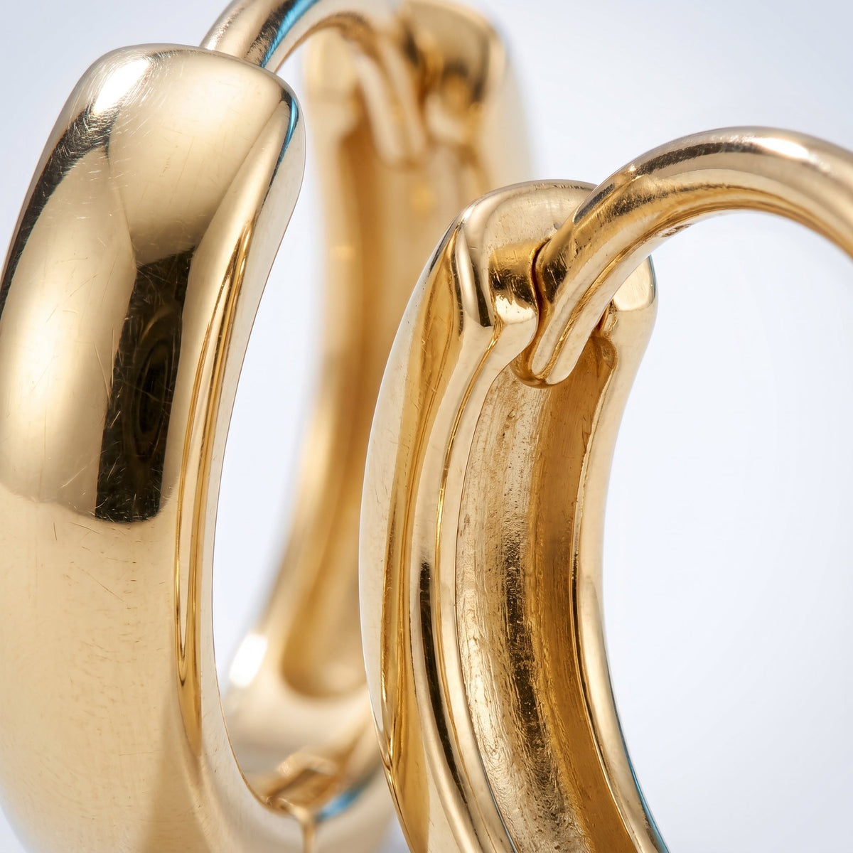 Pendientes huggie lisos bañados en oro de 18K, detalle de cerca