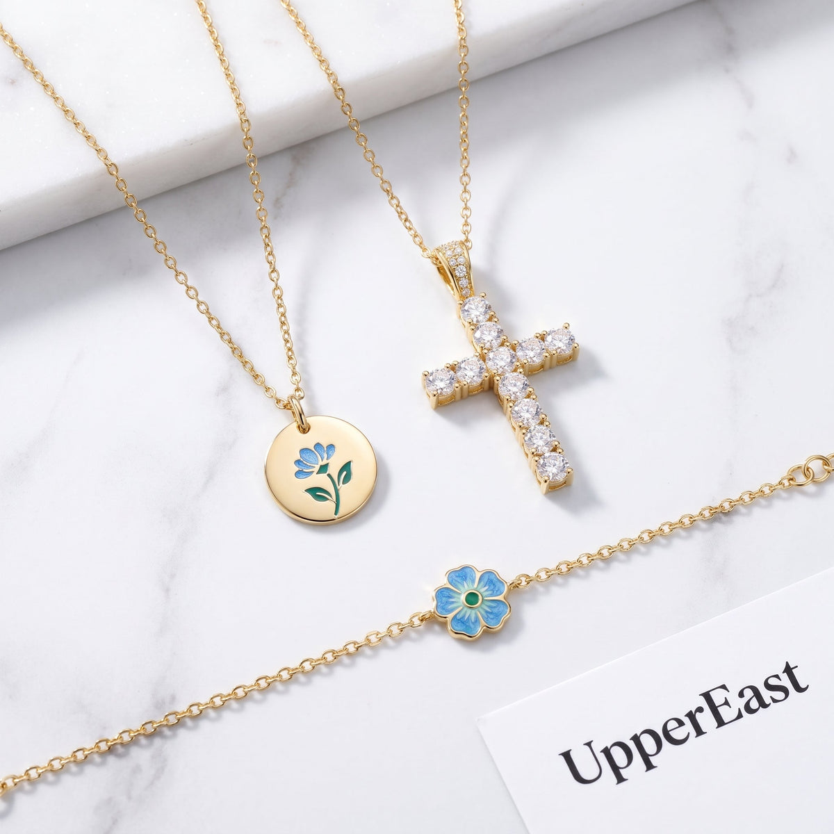 Collar con cruz pequeña bañado en oro de 18K combinado con otras joyas UpperEast