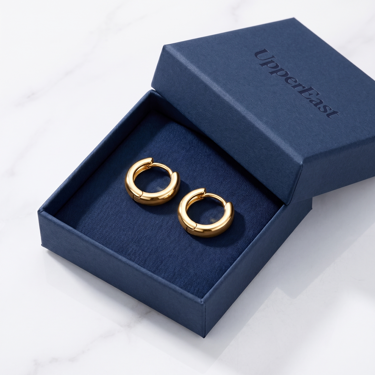 Pendientes huggie lisos bañados en oro de 18K en el estuche UpperEast