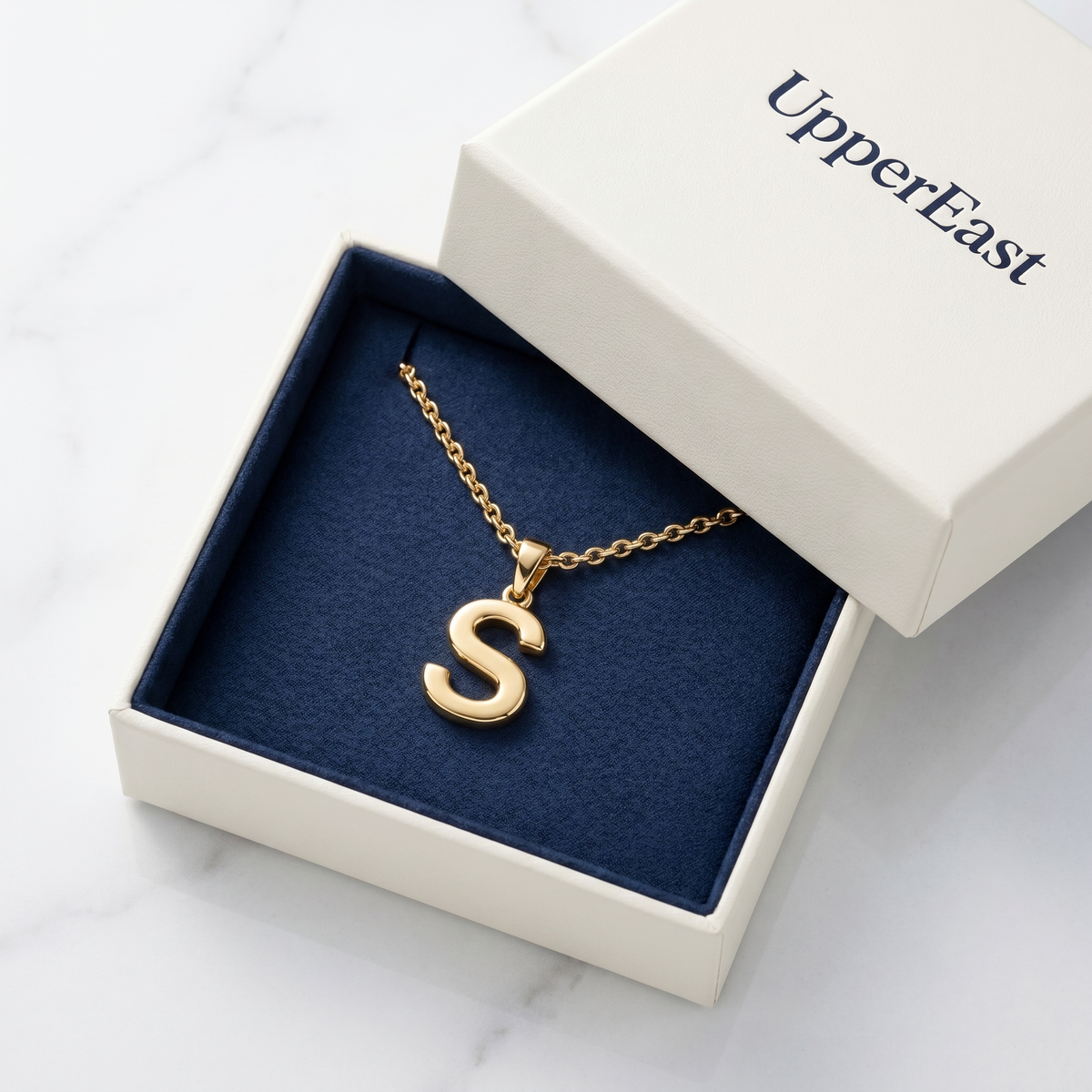 Collar con inicial en cursiva bañado en oro de 18K en el estuche UpperEast
