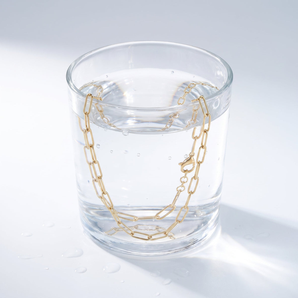 Collana catena paperclip placcata oro 18K in un bicchiere d'acqua