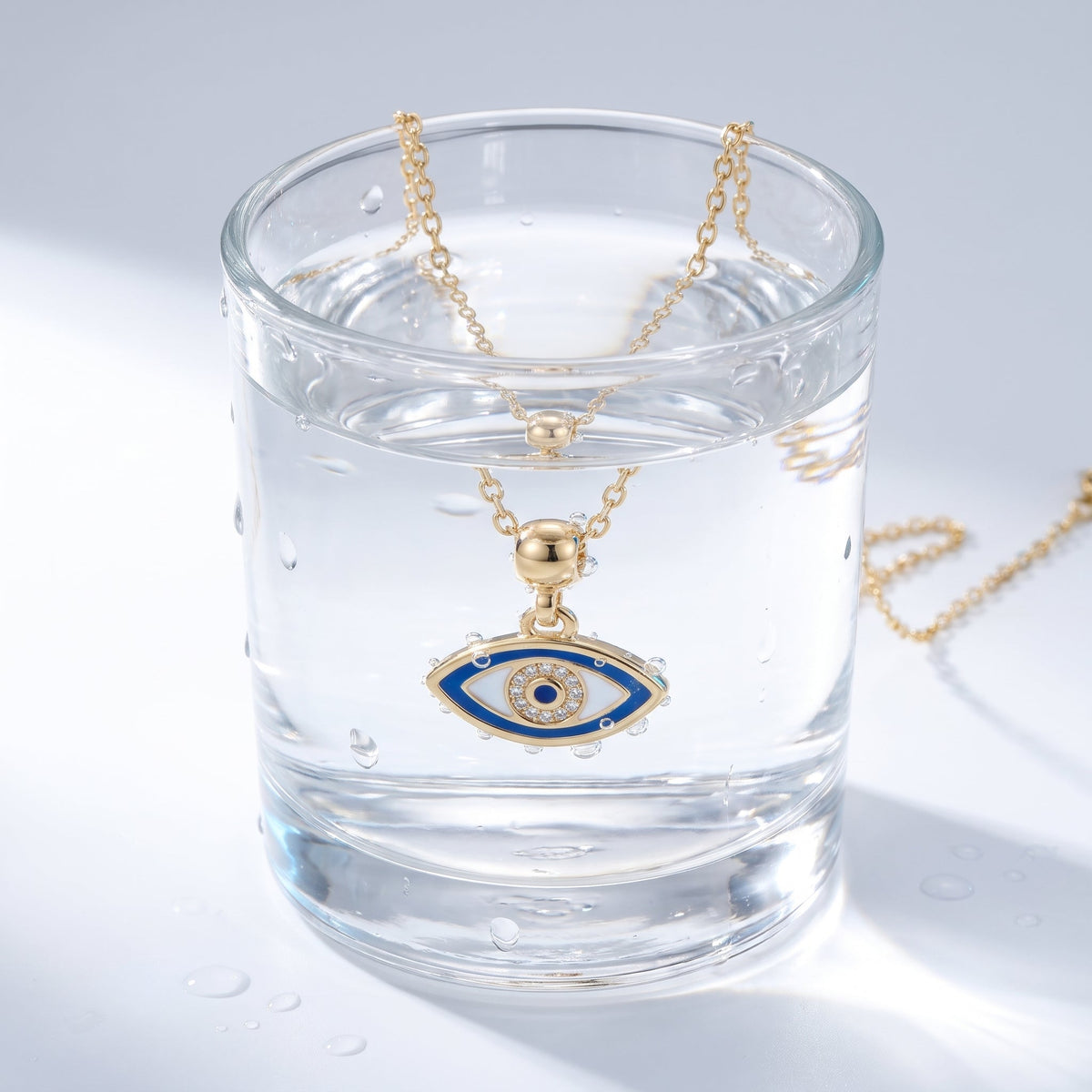 Collar amuleto ojo turco bañado en oro de 18K en un vaso de agua