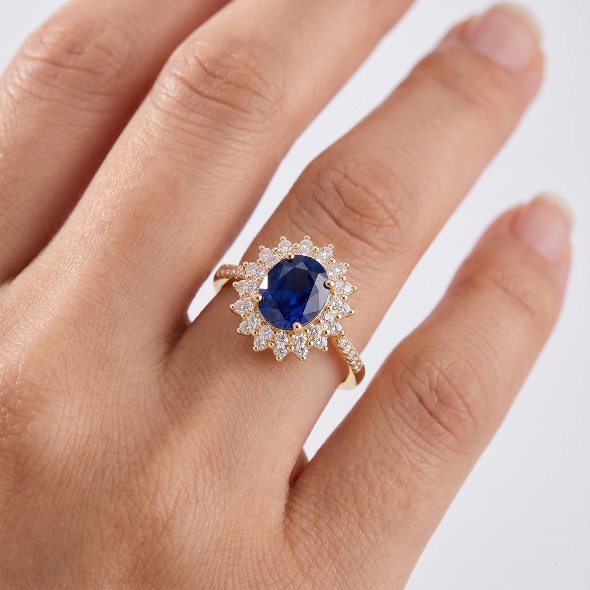 Anello con pietra blu e zirconi placcato oro 18K indossato, primo piano