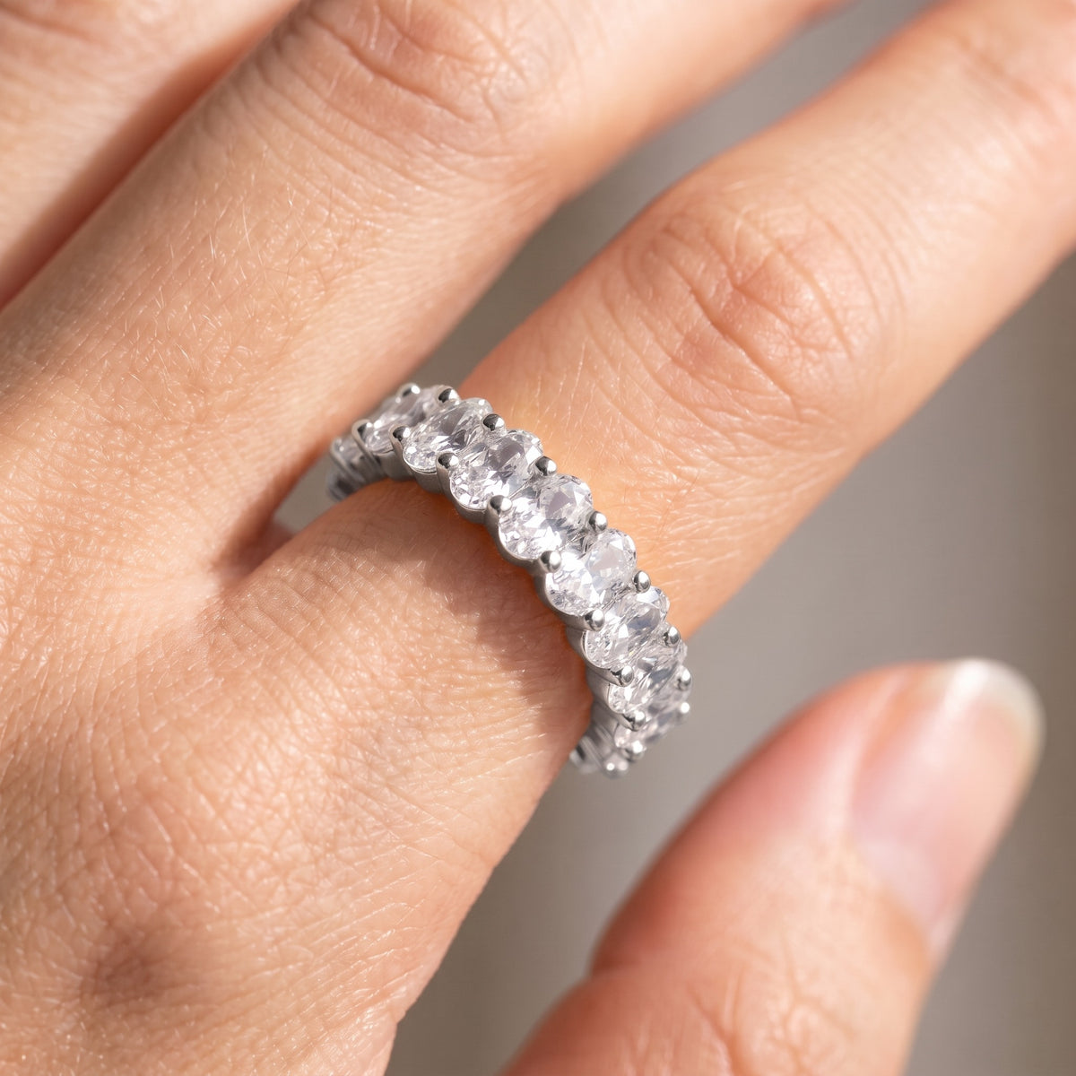 Anillo eternity con circonitas ovaladas color plata puesto, primer plano