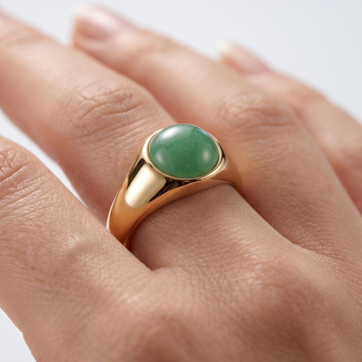 Anillo sello con piedra verde bañado en oro de 18K puesto, primer plano
