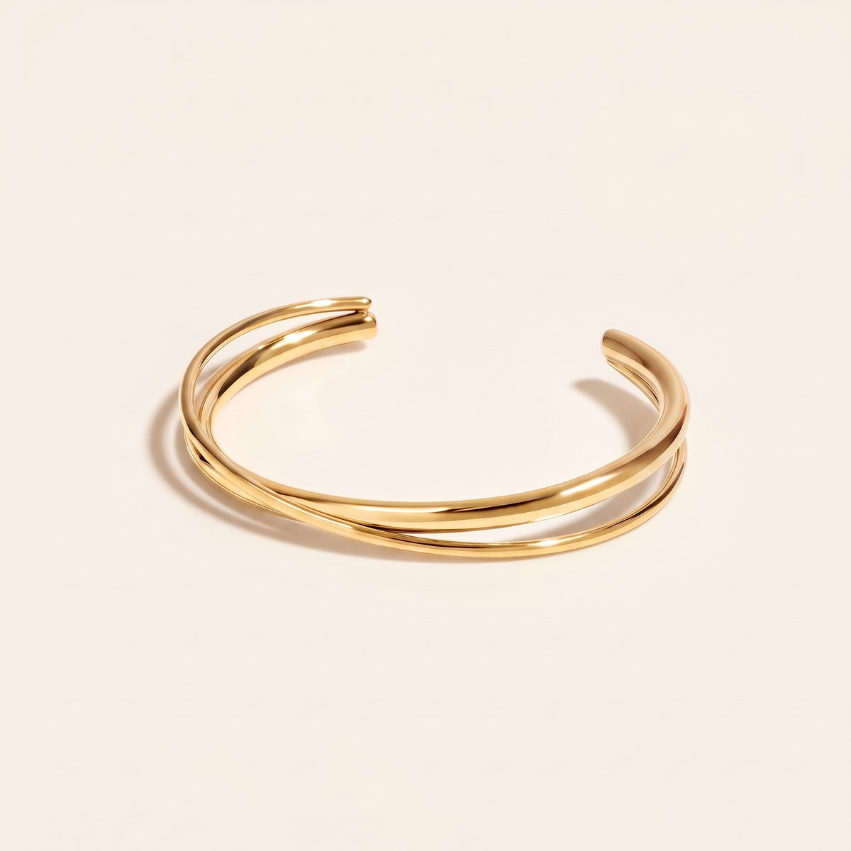 Brazalete rígido cruzado bañado en oro de 18K