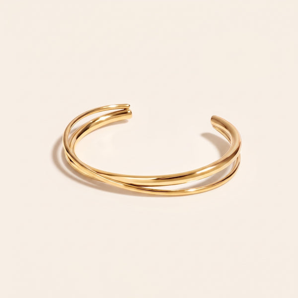 Brazalete rígido cruzado bañado en oro de 18K