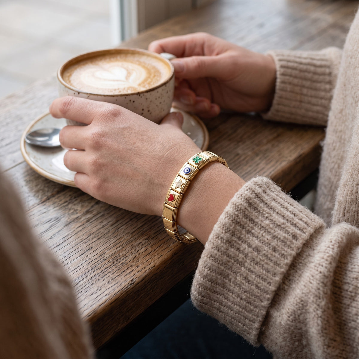Pulsera modular con charms bañada en oro de 18K puesta en un look de diario