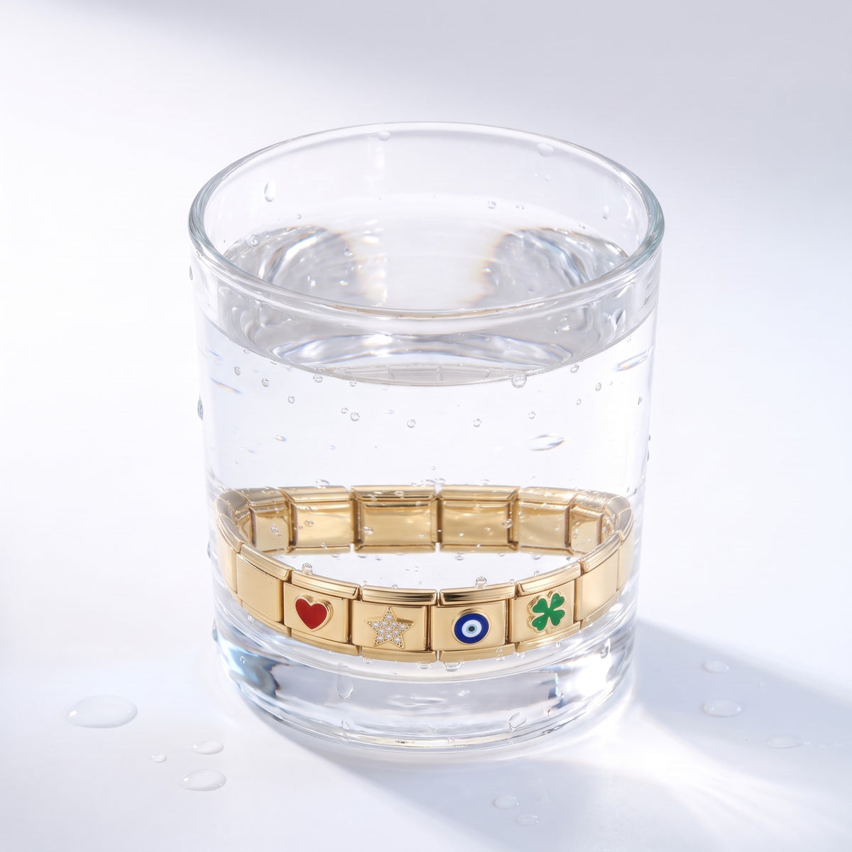 Pulsera modular con charms bañada en oro de 18K sumergida en el agua