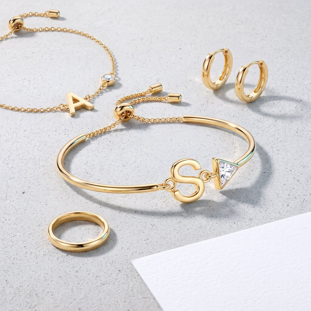 Pulsera con inicial y cristal bañada en oro de 18K combinada con otras joyas UpperEast