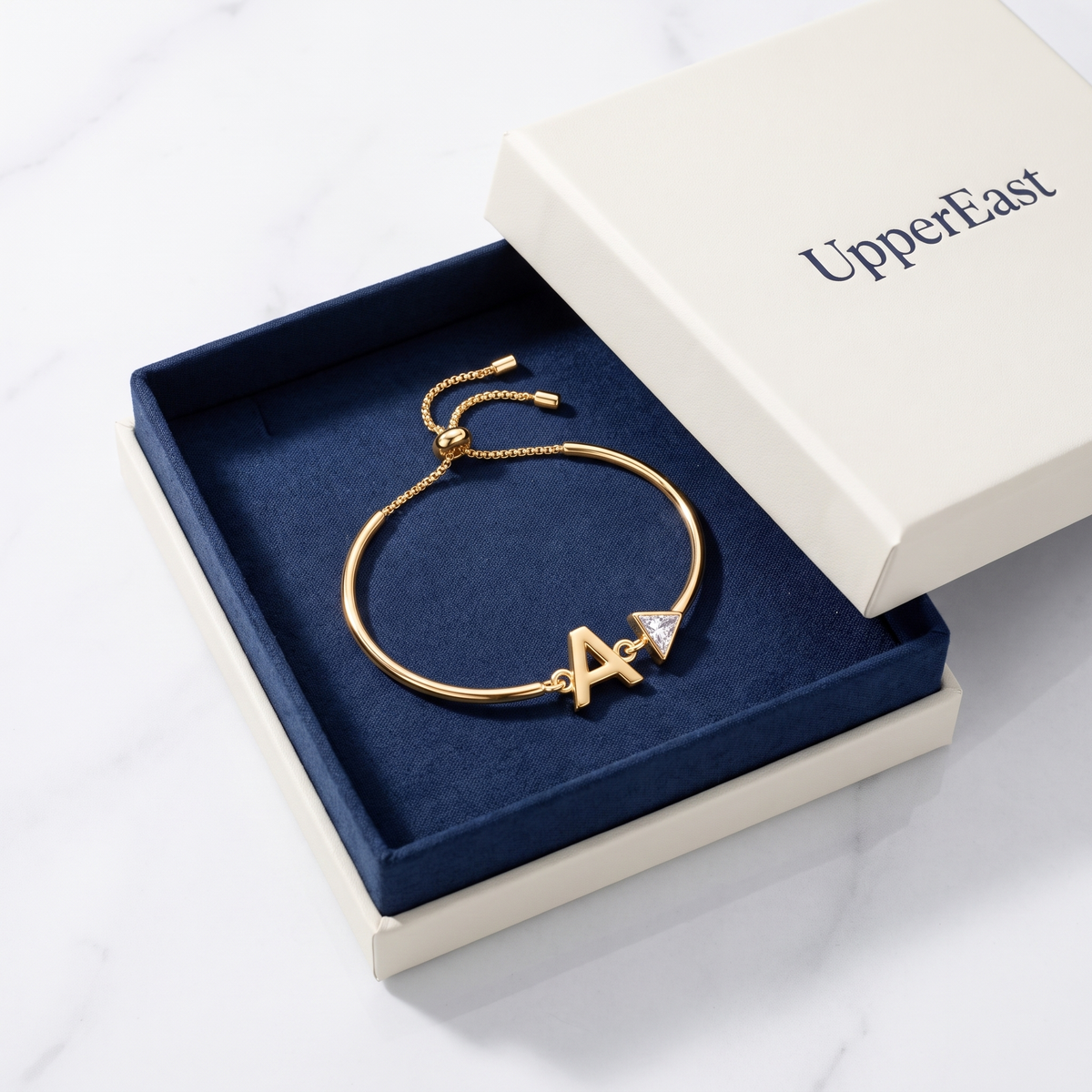 Pulsera con inicial y cristal bañada en oro de 18K en el estuche UpperEast