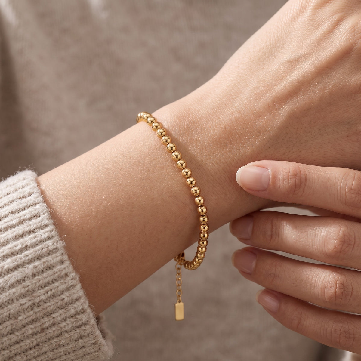 Bracciale a palline placcato oro 18K indossato, primo piano
