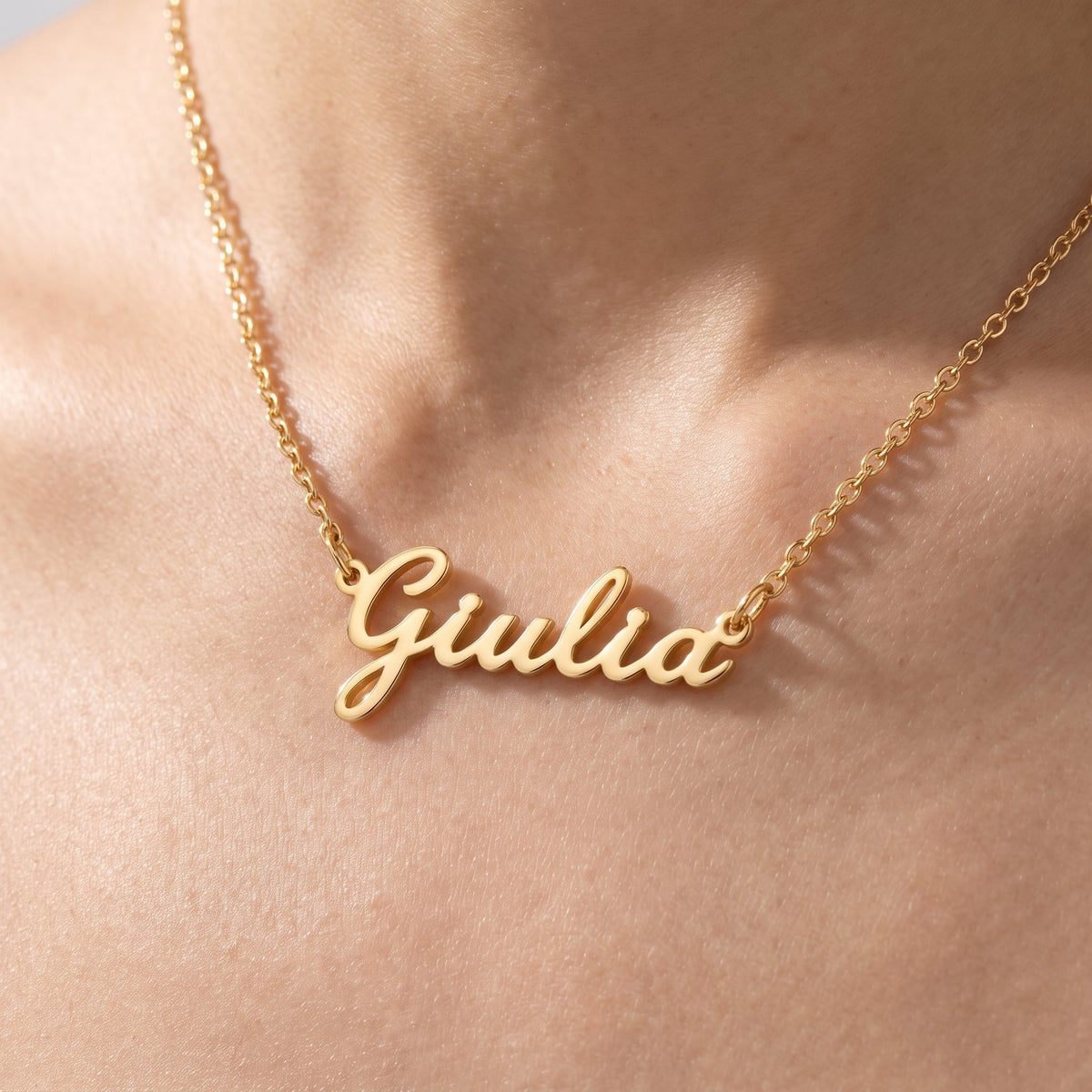 Collar con nombre en cursiva bañado en oro de 18K puesto, primer plano
