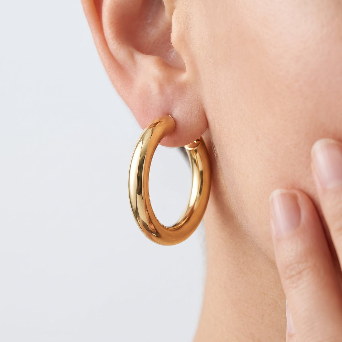 Pendientes de aro gruesos chunky bañados en oro de 18K puestos, primer plano