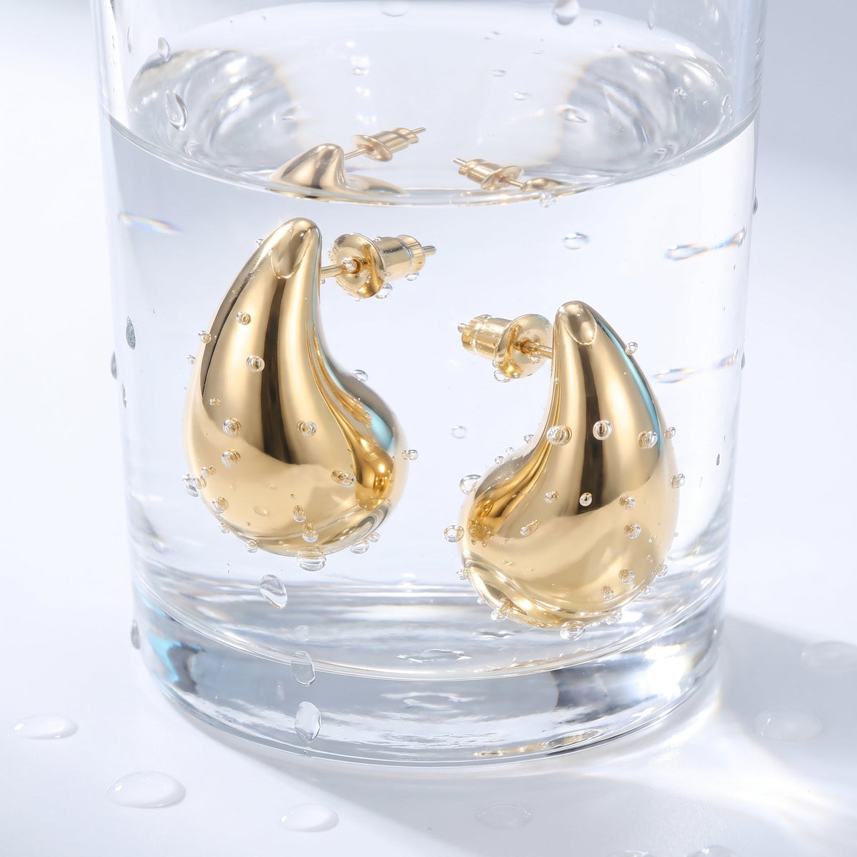Orecchini goccia bombata leggeri placcati oro 18K in un bicchiere d'acqua