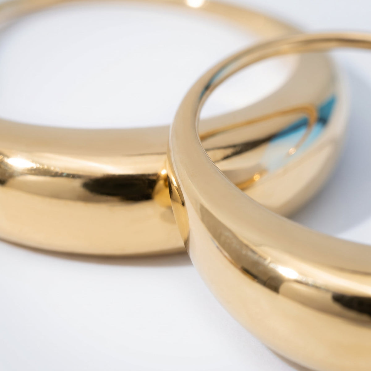 Pendientes ovalados pasantes bañados en oro de 18K, detalle de cerca