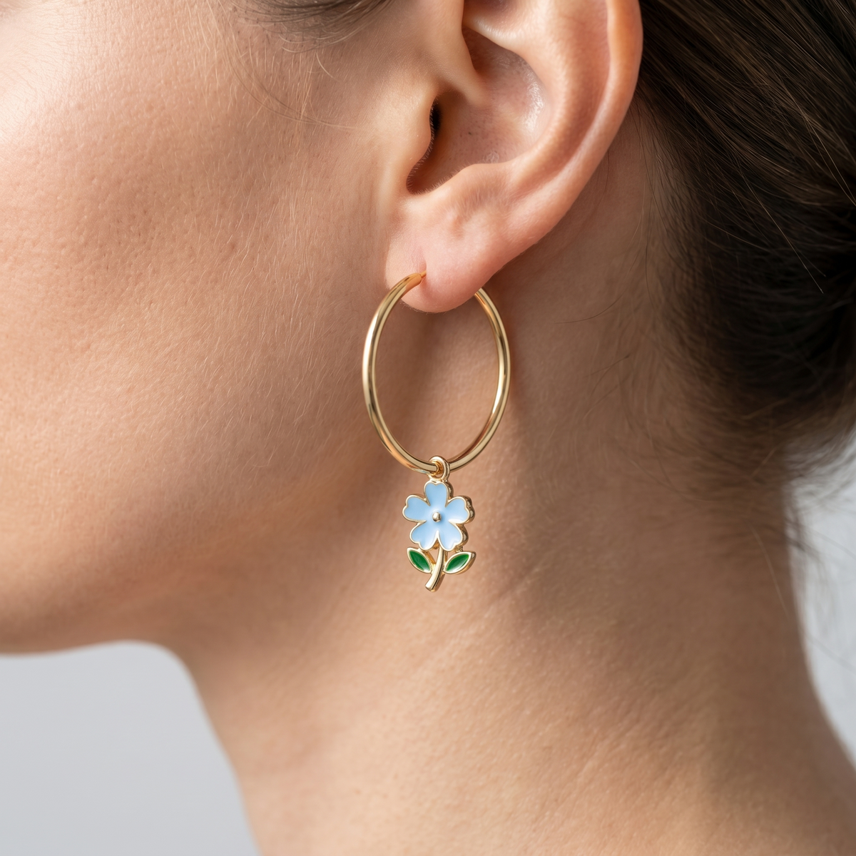 Pendientes de aro maxi con flores bañados en oro de 18K puestos, primer plano