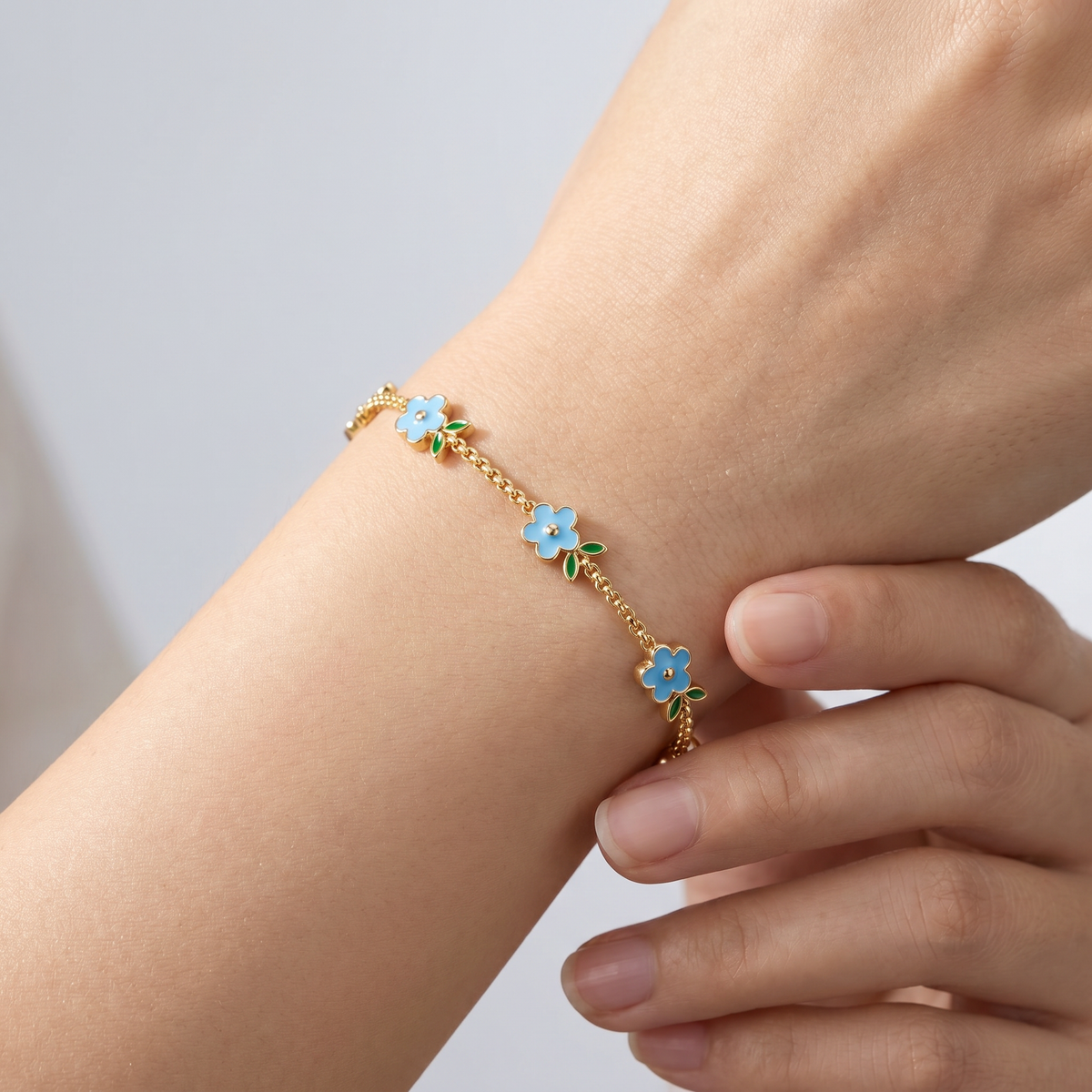 Pulsera con flores esmaltadas bañada en oro de 18K puesta, primer plano