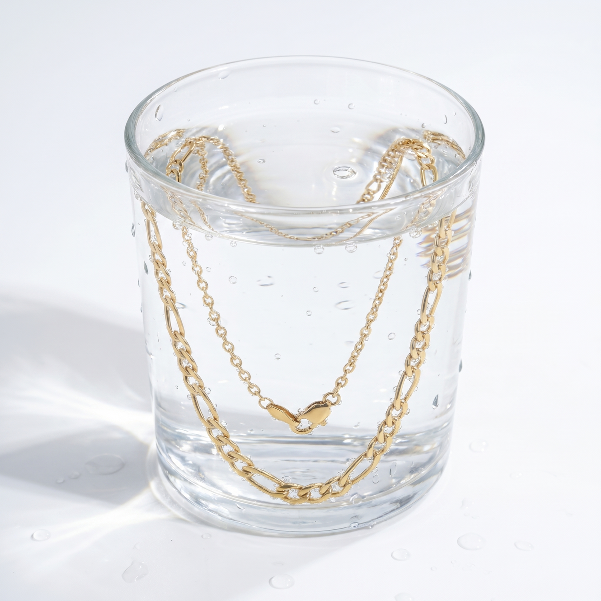 Collar doble figaro en capas bañado en oro de 18K en un vaso de agua