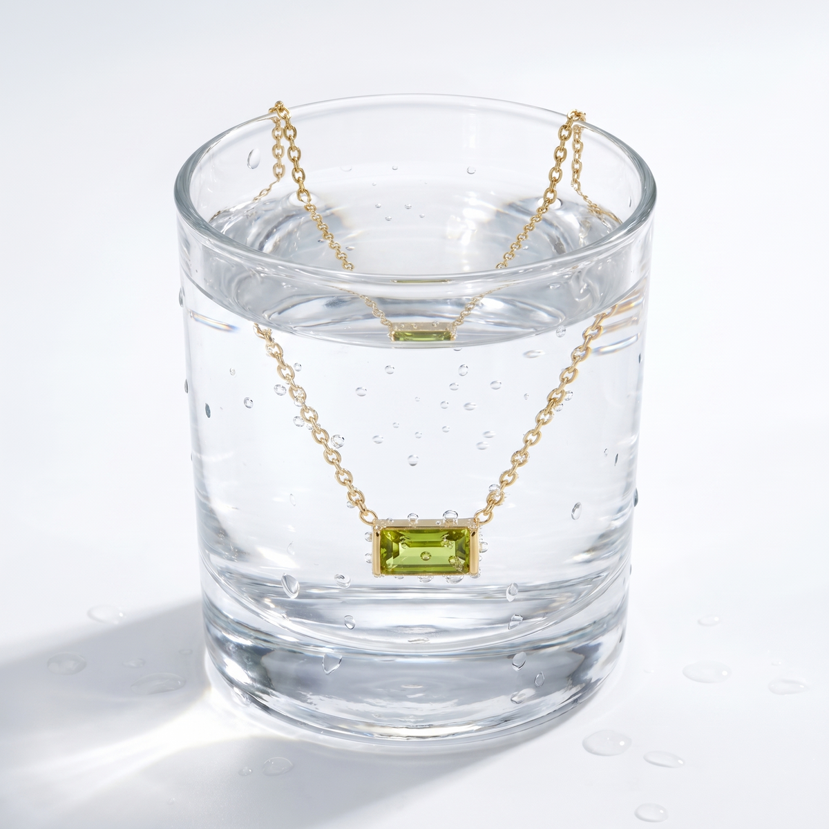 Collana peridoto baguette placcata oro 18K in un bicchiere d'acqua