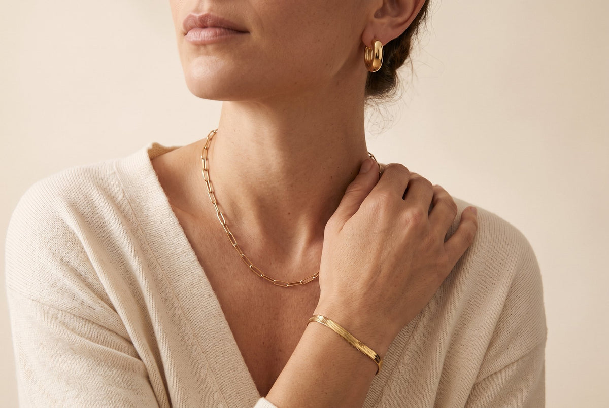 Aros huggie, collar paperclip y pulsera snake bañados en oro de 18K, puestos