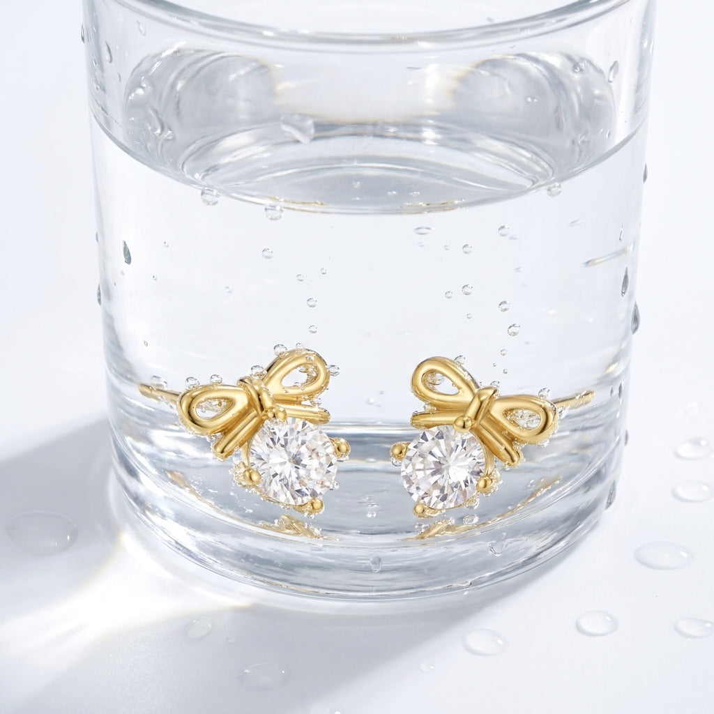 Orecchini fiocco con cristallo placcati oro 18K in un bicchiere d'acqua
