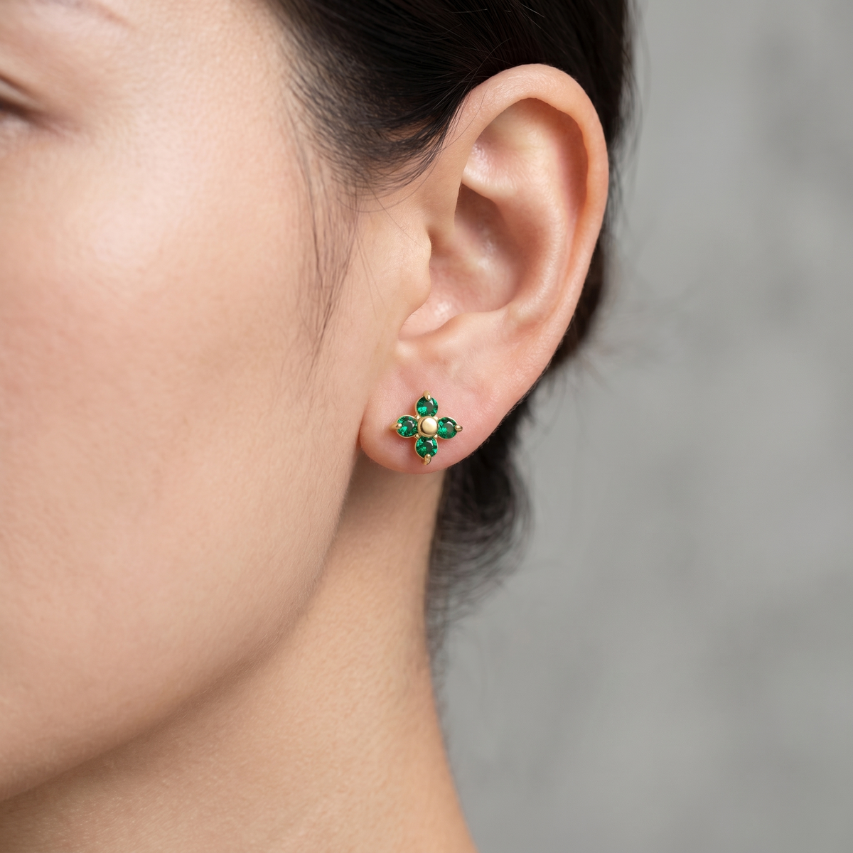 Pendientes flor verde esmeralda bañados en oro de 18K puestos, primer plano
