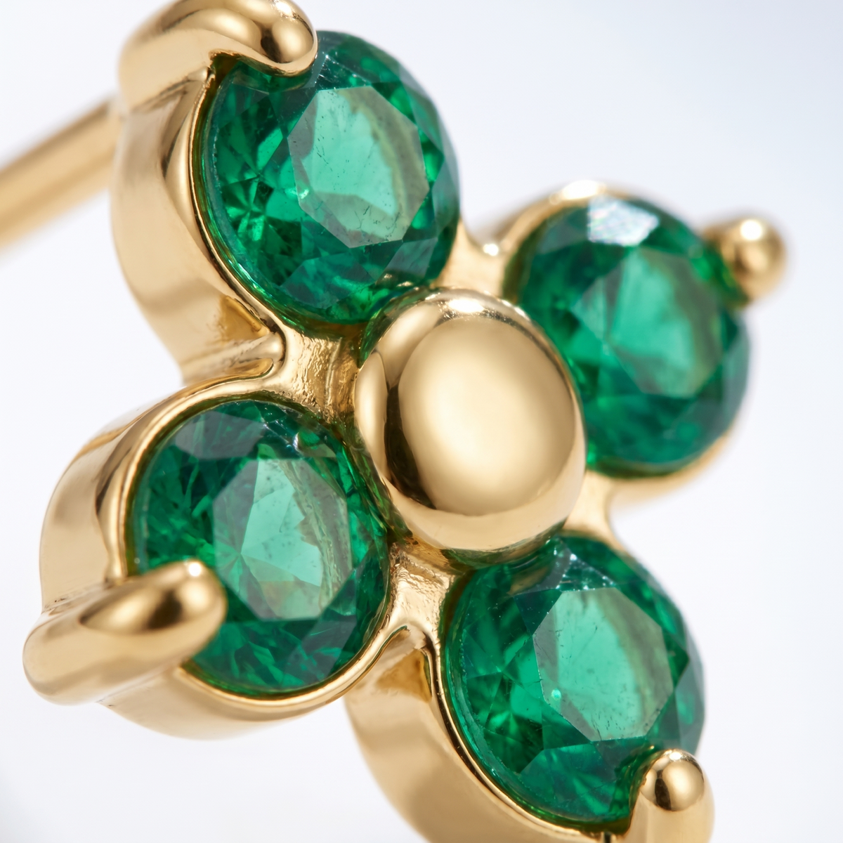 Pendientes flor verde esmeralda bañados en oro de 18K, detalle de cerca