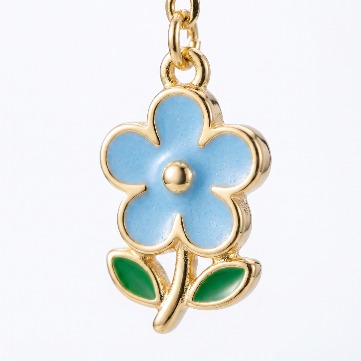 Pendientes gota con flor bañados en oro de 18K, detalle de cerca