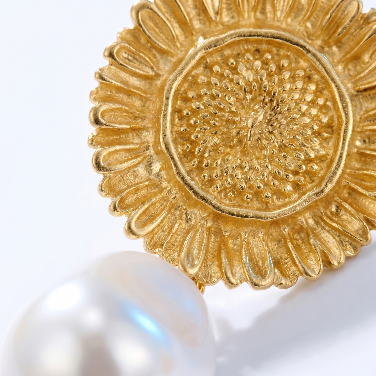 Pendientes colgantes de sol y perla bañados en oro de 18K, detalle de cerca