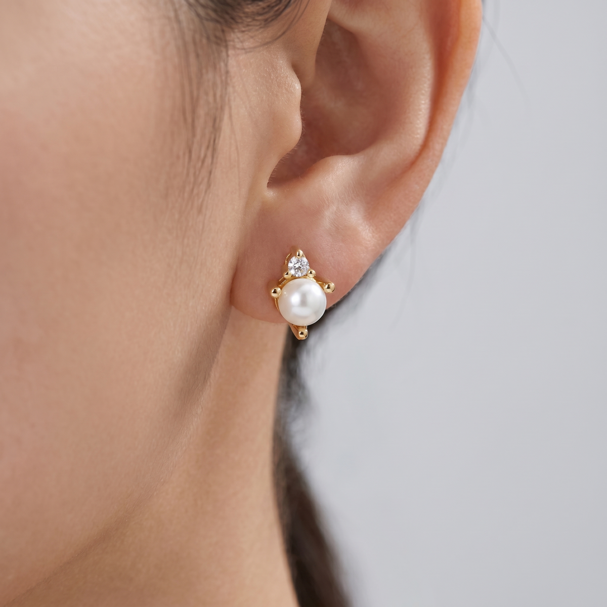 Pendientes de perla y cristal bañados en oro de 18K puestos, primer plano