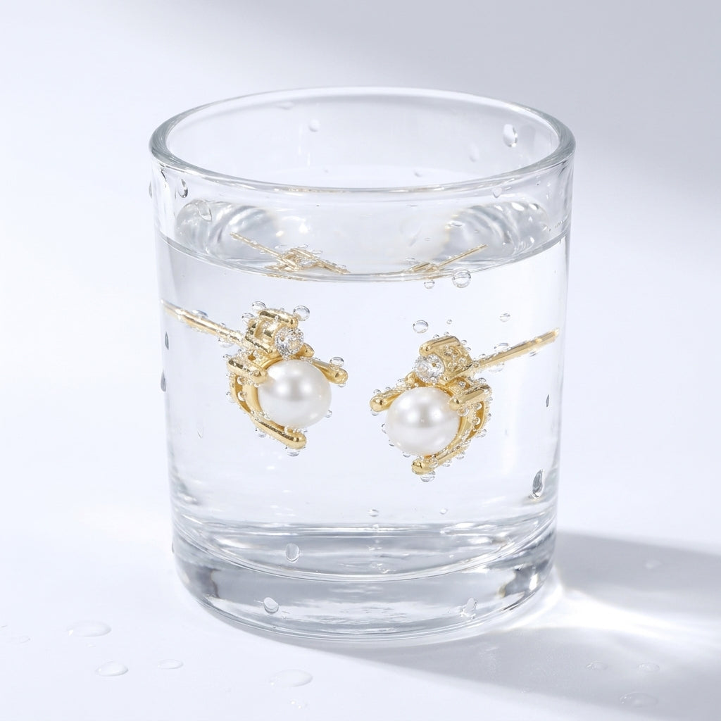 Pendientes de perla y cristal bañados en oro de 18K en un vaso de agua